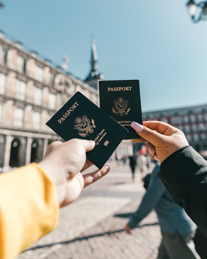 Anonymous tourists showing US passports on street on sunny day